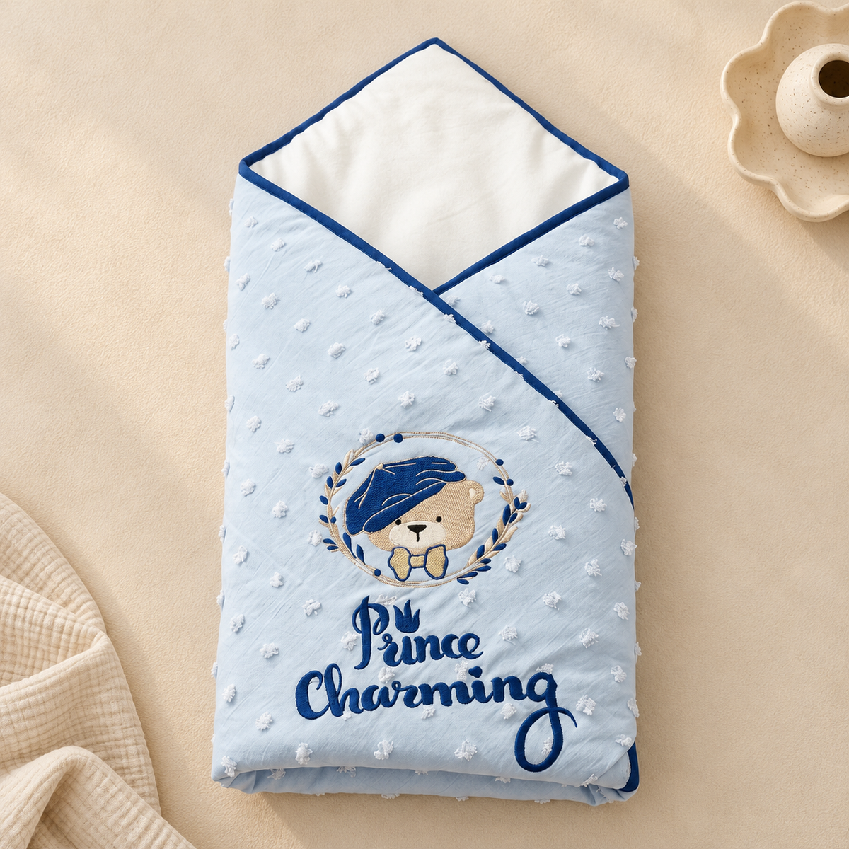 A light blue minky dot swaddle blanket with a teddy bear graphic and the text 'Prince Charming' on a beige background.