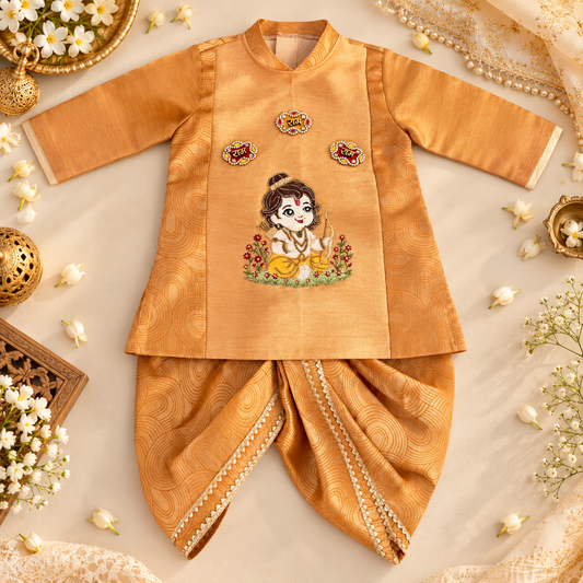 A traditional Indian baby outfit set in golden yellow fabric, featuring a long-sleeve embroidered top and matching pants, styled in a flat lay with decorative flowers and jewelry.