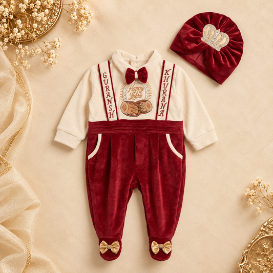 A baby boy's two-piece velvet outfit set featuring a long-sleeve romper and a matching beanie. The romper has a cream-colored upper chest and sleeves, red suspenders with 'KURUSH' and 'MATHANA' text, a red bow tie, and red pants with gold bow-tie details on the feet.
