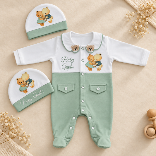 A baby clothing set laid flat on a beige fabric background, including a long-sleeve footless romper and two matching beanies. The romper is white on the upper chest and collar, with mint green lower body and legs, snap closures, two front pockets, and teddy bear graphics with the text 'Baby Gupta.