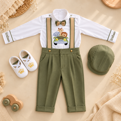 A baby boy's formal outfit set laid flat on a beige fabric background, including a white long-sleeve shirt with 'Harrison' printed on the cuffs, olive green suspenders, matching olive green trousers, a brown bow tie, and a small safari-themed chest print. A matching olive green cap, white baby shoes, and decorative props are arranged around it.