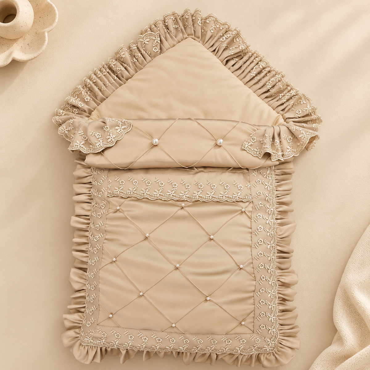A beige quilted fabric pouch with a house-shaped hood, featuring delicate lace trim, ruffled edges, and small pearl-like accents, laid flat on a matching beige fabric background.