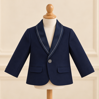 A navy blue boys' blazer with white contrast piping along the shawl collar and a single silver button, displayed on a cream-colored mannequin torso.