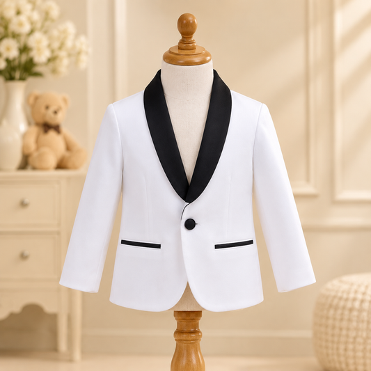A white children's blazer with black satin lapels and trim, displayed on a wooden dress form mannequin. The blazer features a single black button and two front welt pockets.