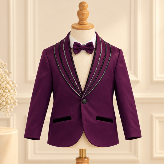 A boy's formal jacket in deep purple with black velvet trim and silver beaded lapels, displayed on a mannequin with a matching purple bow tie.